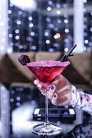 Woman Holding Martini Glass With Berry on Rim photo