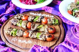 Skewers of Meat and Veggies on Wooden Board photo