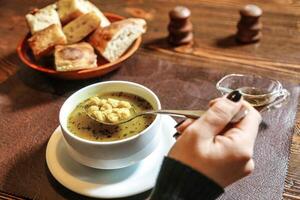 Bowl of Soup With Spoon on Wooden Table photo