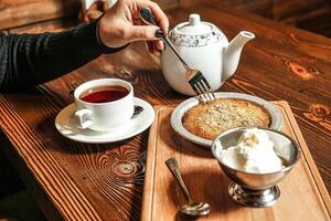 persona sentado a mesa con plato de comida y taza de té foto