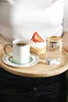 Person Holding Tray With Coffee Cup and Pastry photo