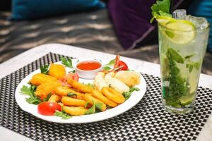 deliciosamente preparado plato de comida y refrescante bebida en mesa foto