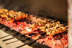 Skewers of Various Foods Cooking on a Grill photo