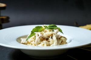 blanco cuenco lleno con pasta, adornado con menta foto