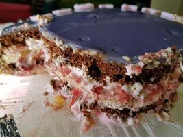 The central slice of a cake with cream, chocolate and berries photo