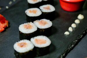 Sushi on Black Plate With Red Sauce Container photo