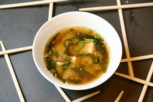 cuenco de sopa con palillos en mesa foto