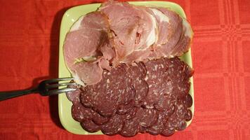 Mixed cold cuts of pork served on a green plate photo