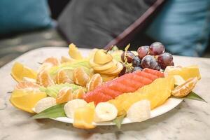 blanco plato con clasificado frutas en mesa foto