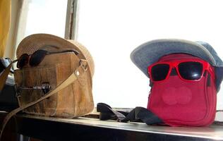 a red bag and a cork bag with glasses photo