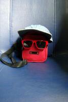 a red bag and a cork bag with glasses photo