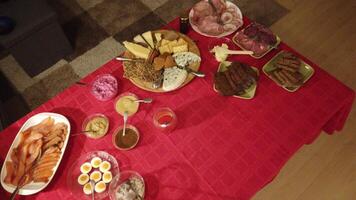 video of a buffet with bread, beetroot salad, various types of mustard, hard boiled eggs with fish roe, salmon, herring in sauce, pastries and mixed cold cuts photo