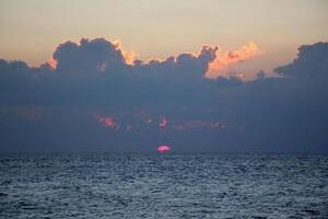 Encendiendo y color de el cielo encima el horizonte a puesta de sol. foto