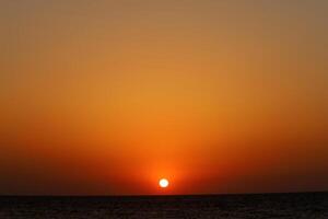 Encendiendo y color de el cielo encima el horizonte a puesta de sol. foto