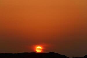 Encendiendo y color de el cielo encima el horizonte a puesta de sol. foto