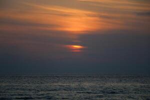 Encendiendo y color de el cielo encima el horizonte a puesta de sol. foto