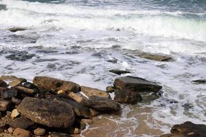 Stones and shells on the shore of the Mediterranean Sea. photo