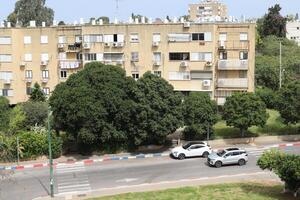 Tel Aviv Israel 03 28 2024. Buildings and structures in Tel Aviv through the foliage of tall trees. photo