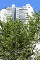 Tel Aviv Israel 03 28 2024. Buildings and structures in Tel Aviv through the foliage of tall trees. photo