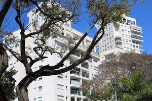 Tel Aviv Israel 03 28 2024. Buildings and structures in Tel Aviv through the foliage of tall trees. photo