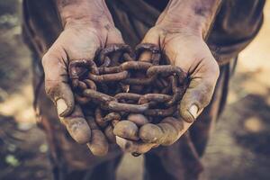 foto dos masculino manos participación un oxidado metal cadena