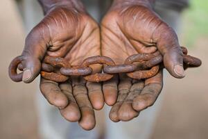 Photo two male hands holding a rusty metal chain