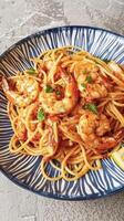 pasta con camarones, Tomates y albahaca en un plato foto