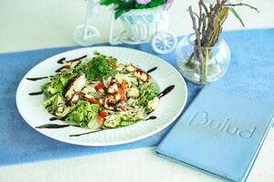 White Plate Topped With Salad Next to Vase of Flowers photo