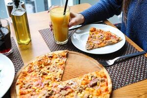 Person Sitting at Table With Two Slices of Pizza photo