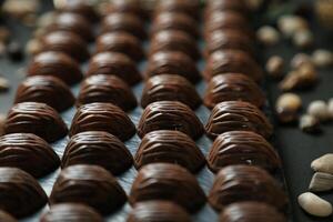 cerca arriba de clasificado chocolates y nueces desplegado en un bandeja foto