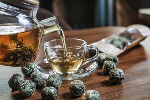 Pouring a Cup of Tea Into a Glass Cup photo