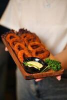 Person Holding Tray of Onion Rings photo