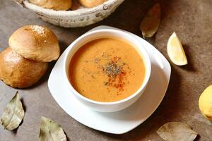 Bowl of Soup With Freshly Baked Rolls photo