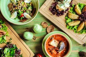 mesa adornado con platos de comida y bochas de sopa foto