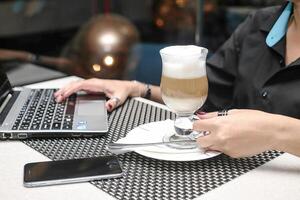 Woman Sitting at Table Using Laptop Computer for Work photo