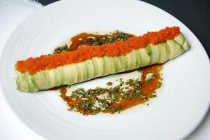 White Plate With Cucumber Covered in Sauce photo