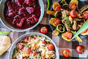 mesa adornado con un surtido de delicioso comida y Fresco vegetales foto