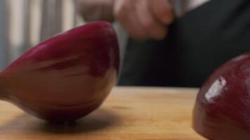 Professional chef cuts red onion. Slow motion. video