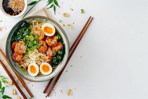 Asian ramen noodles on a white background. Egg noodles, eggs, meat, seaweed. There are ingredients scattered nearby, an empty space. photo