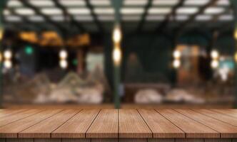 Empty wooden table top with lights bokeh on blur restaurant background photo