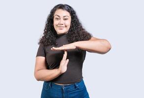 sonriente mujer demostración hora fuera gesto aislado. joven mujer haciendo hora fuera gesto con palmas aislado foto