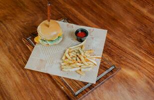 Top view of cheeseburger with french fries served on wooden table. Delicious hamburger with french fries on a wooden table photo