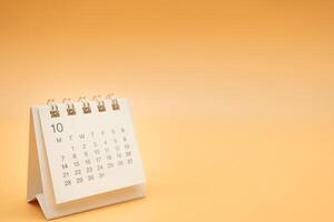 Desk calendar for OCTOBER with no year isolated on orange background. Calendar concept with copy space. Desktop Calendar for Planner and management. photo