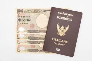 Thai passport and japan money for travel on isolated background with copy space. Thai people prepared for vacation to Japan. photo