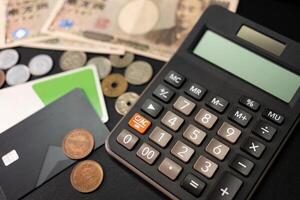 calculadora, yen japonés moneda y ic tarjeta. vacaciones, planificación presupuesto. foto