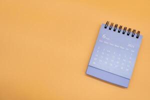 Blue desk calendar for JUNE 2024 isolated on orange background. Calendar concept with copy space. Flat lay. photo