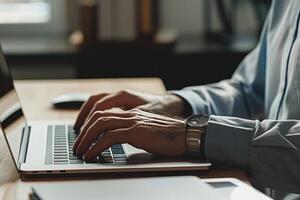 Businessman hand typing on laptop computer, working in modern office interior photo