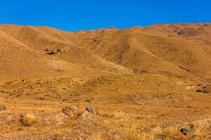 a mountain range with a blue sky in the background photo