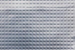 Closeup full-frame background and texture of aluminum coated butil rubber sheet with square pattern. photo