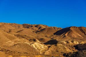 a mountain range with a blue sky in the background photo